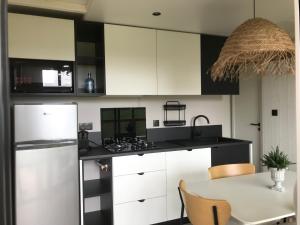 a kitchen with white and black cabinets and a table at Martinette in Saint-Pair-sur-Mer