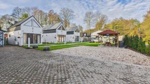 a large house with a cobblestone driveway at Dębówka in Wilcze