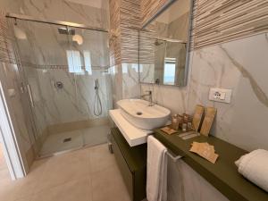 a bathroom with a sink and a shower at Suites Prestige in Peschici +63 photos