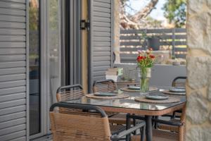 a patio table with chairs and a vase of flowers at Azure Harmony Pool Villa by SEM in Áyios Spirídhon