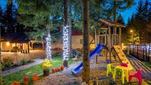 a playground with a slide in a yard with lights at Casa Foresta by Villas Guide in Mrkopalj