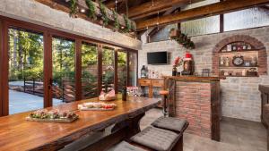 a kitchen with a wooden table and a brick wall at Casa Foresta by Villas Guide in Mrkopalj