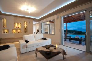 a living room with a white couch and a table at Villa Harmony in Karavomylos