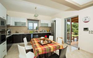 a kitchen and dining room with a table and chairs at Villa Harmony in Karavomylos