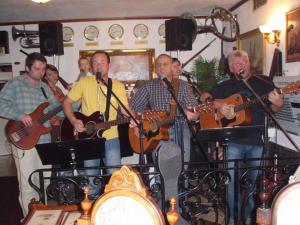 un grupo de hombres tocando instrumentos en una habitación en Hotel Klor, en Doudleby