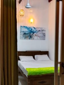 a bedroom with two beds with a green blanket at Sun Beach Villa in Weligama