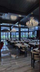 a dining room with tables and chandeliers at Adana Time Business Hotel in Adana