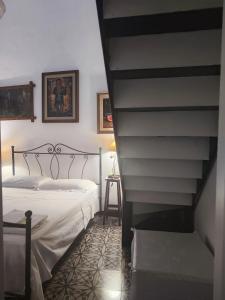 a bedroom with a bed next to a staircase at B&B Palazzo Antonelli in Monopoli