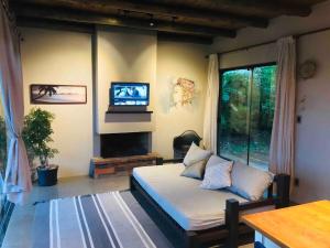 a bedroom with a bed and a tv in a room at Casa Morro da Borússia in Osório