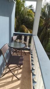 a table and chairs on a balcony with palm trees at The Cupid Chalet Suite in Kingstown