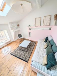 a living room with a couch and a table at Charmant cocon sous les toits de Bordeaux in Bordeaux