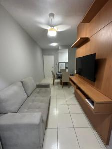a living room with a couch and a flat screen tv at Atlântico condomínio in Serra