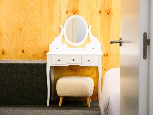 a white dressing table with a mirror and a chair at The Grand Garden Loft in Pamplona