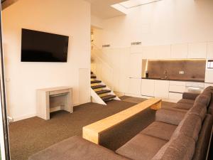 a living room with a couch and a flat screen tv at The Grand Garden Loft in Pamplona