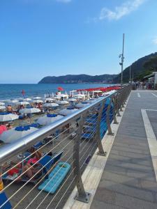 a pier with chairs and people on the beach at Delizioso bilocale Paolo in Alassio