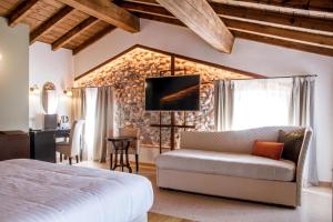 a bedroom with a bed and a table and a kitchen at Corte Regia Relais & Spa in Valeggio sul Mincio