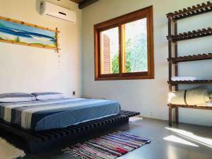a bedroom with a bed and a window at Casa Morro da Borússia in Osório