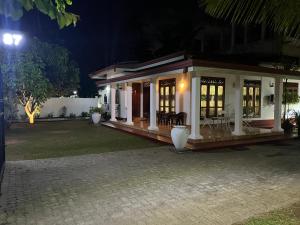 a small house with a porch at night at Villa 87 in Katunayaka
