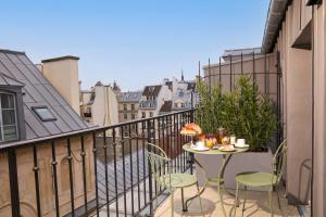 a balcony with a table and chairs on a balcony at Hotel des Orfèvres in Paris