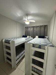 a room with two beds and a ceiling at Atlântico condomínio in Serra