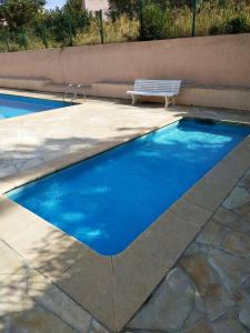 a swimming pool with a bench next to it at Monplaisir in Fréjus