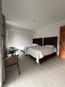 a bedroom with two beds and a table in it at Hotel Zaniah in Huancayo