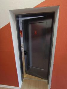 a black door with the number in a wall at Travel Hub Hostel Social and Friendly in Ohrid +47 photos
