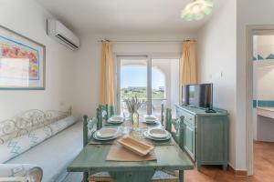 a dining room with a green table and a television at Dreamy apartment in Orosei in Orosei
