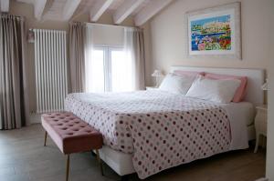 a bedroom with a pink and white bed and a window at B&B La Fiaba in Sirmione