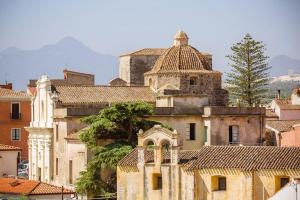 a group of buildings in a city with mountains at Dreamy apartment in Orosei in Orosei