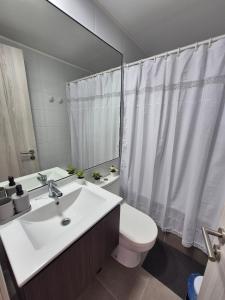 a bathroom with a sink and a toilet and a mirror at Apartment in Playa Brava Ocean View & SmartLock in Iquique +8 photos