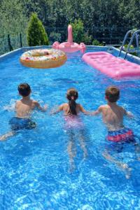 three children are playing in a swimming pool at El eco de los robles in Sumbilla