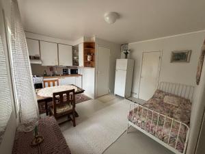 a kitchen with a bed and a table and a refrigerator at Studio Sillankorva in Viitasaari