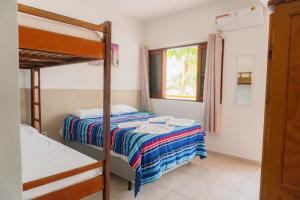 a bedroom with two bunk beds and a window at Pousada Acquaville PISCINA CLIMATIZADA in Bertioga