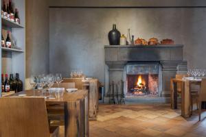 a dining room with a fireplace and tables and chairs at Wine Resort Villagrande in Milo
