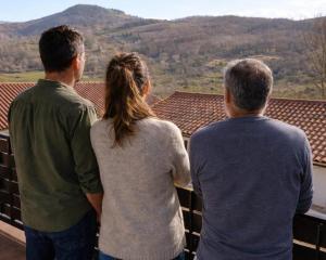 a group of three people looking out over a roof at El eco de los robles in Sumbilla