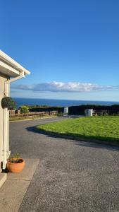 a driveway to a house with a view of the ocean at Follies Garden Studio in Dungarvan