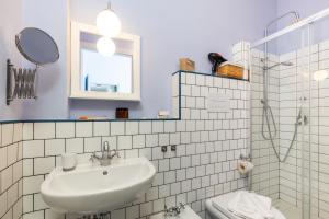 a bathroom with a sink and a toilet and a mirror at Giaminera Rooms & Art Studio in Baunei +82 photos