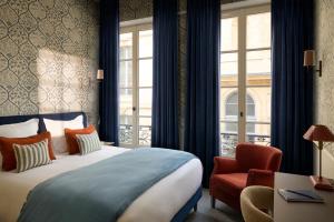 a hotel room with a bed and a window at Hotel des Orfèvres in Paris