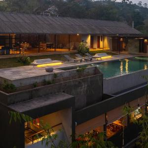 an external view of a house with a swimming pool at VAASTA Vagamon in Vagamon