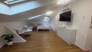 a living room with a couch and a tv on the wall at Penzion Aladdin in Teplice