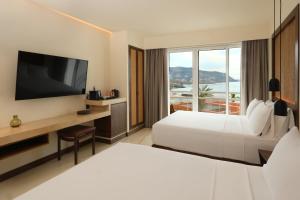 a hotel room with a bed and a television at Hotel Indigo La Paz Puerta Cortes by IHG in La Paz