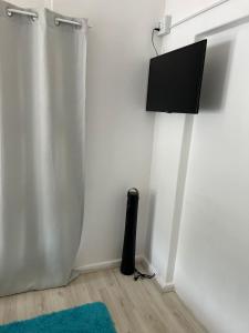 a corner of a room with a flat screen tv on a wall at Durbanville Queens and Kings Guest House in Cape Town