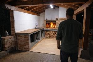 a man standing in front of a kitchen with a fireplace at El eco de los robles in Sumbilla