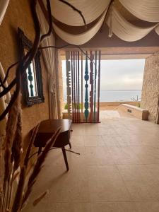 a room with a table and a view of the ocean at Samarah EP 04 full Sea View and poll access prime location with big terrace, in Sowayma