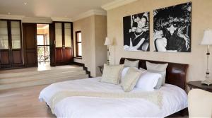 a bedroom with a large bed with white sheets at Villa Seaview, Private Oceanfront Villa, Heated Pool & Whale Watching Views, Knysna Heads in Knysna