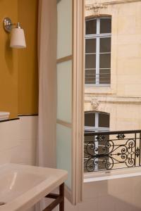 a bathroom with a window and a white sink at Hotel des Orfèvres in Paris +86 photos