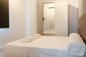 a bedroom with a bed with white sheets and a mirror at Mallorca Rooms Can Pastilla in Can Pastilla +76 photos