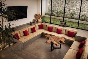 a living room with a large couch with red pillows at Oran Villa Bali in Tampaksiring