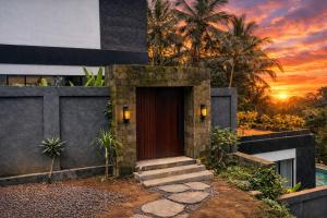 a door to a house with a sunset in the background at Oran Villa Bali in Tampaksiring